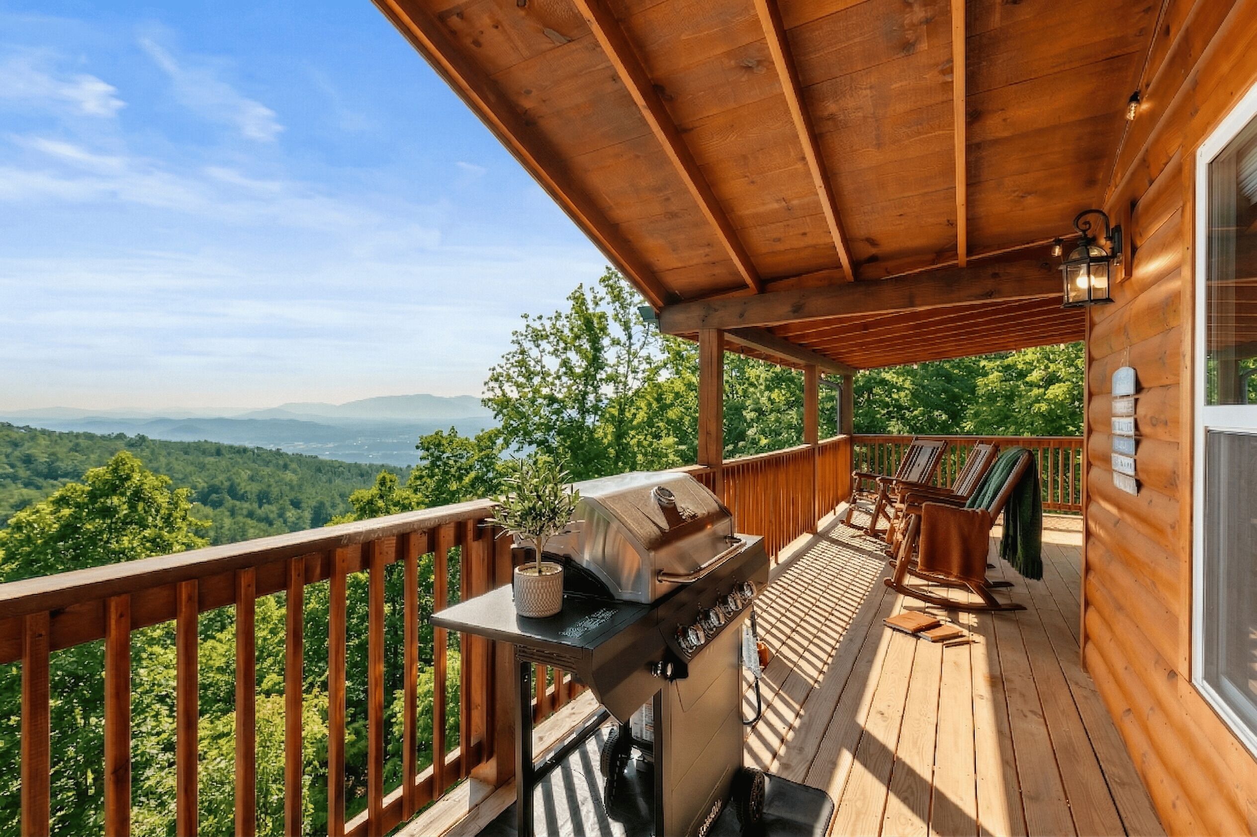 Eine Holzterrasse mit Grill, Stühlen und einem Tisch.