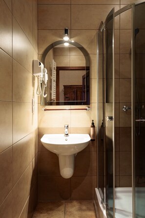 A bathroom with a sink, mirror, and shower. - Butikowy Hotel Zameczek (Książ Wielki)