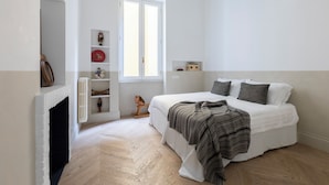 A bedroom with a white bed, a fireplace, and a window. - Casa Luce, a Burghesius home (Roma)