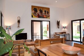 A dining area with wooden furniture, a television, and a painting on the wall.