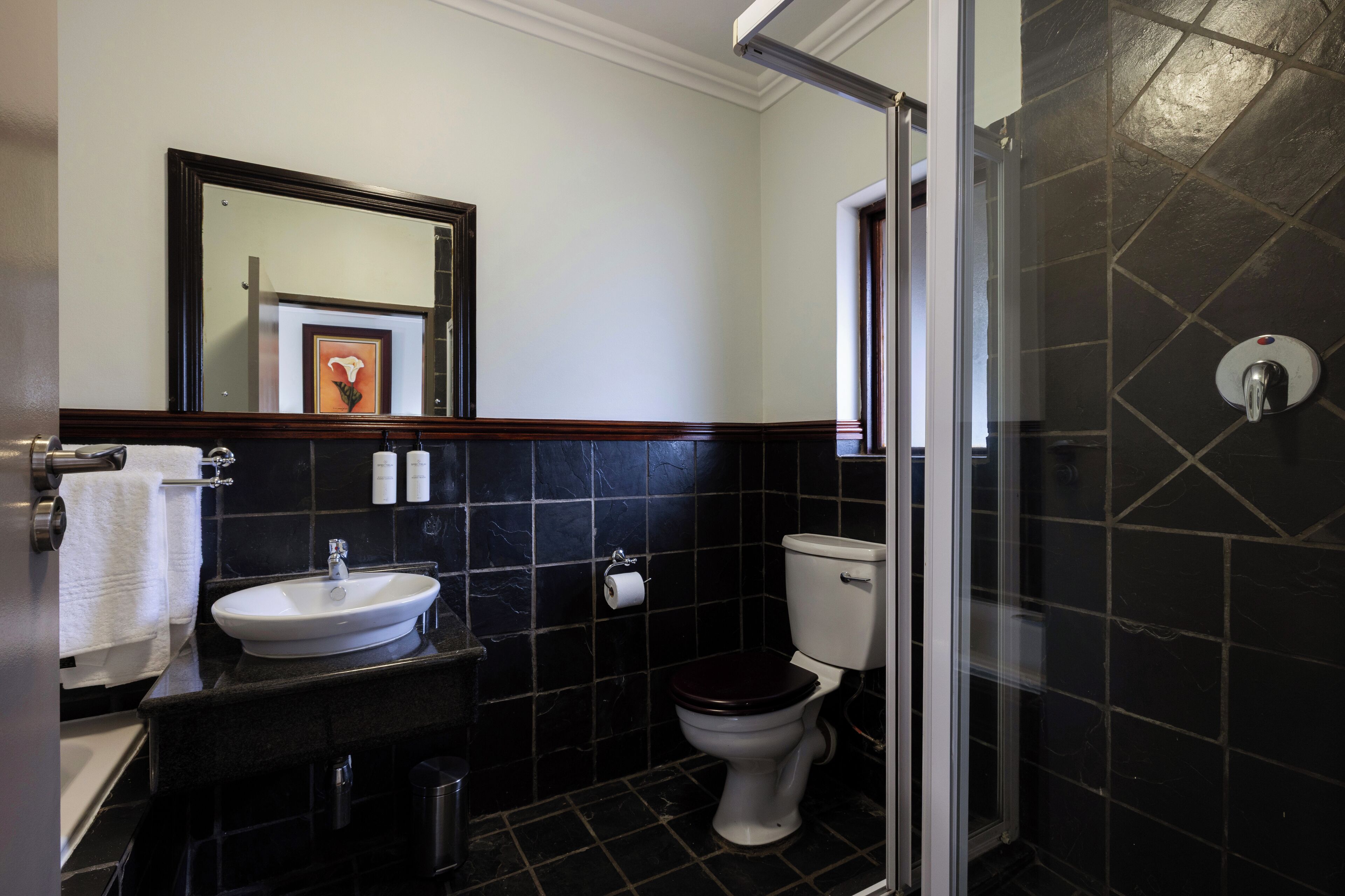 A bathroom with a sink, toilet, and shower.