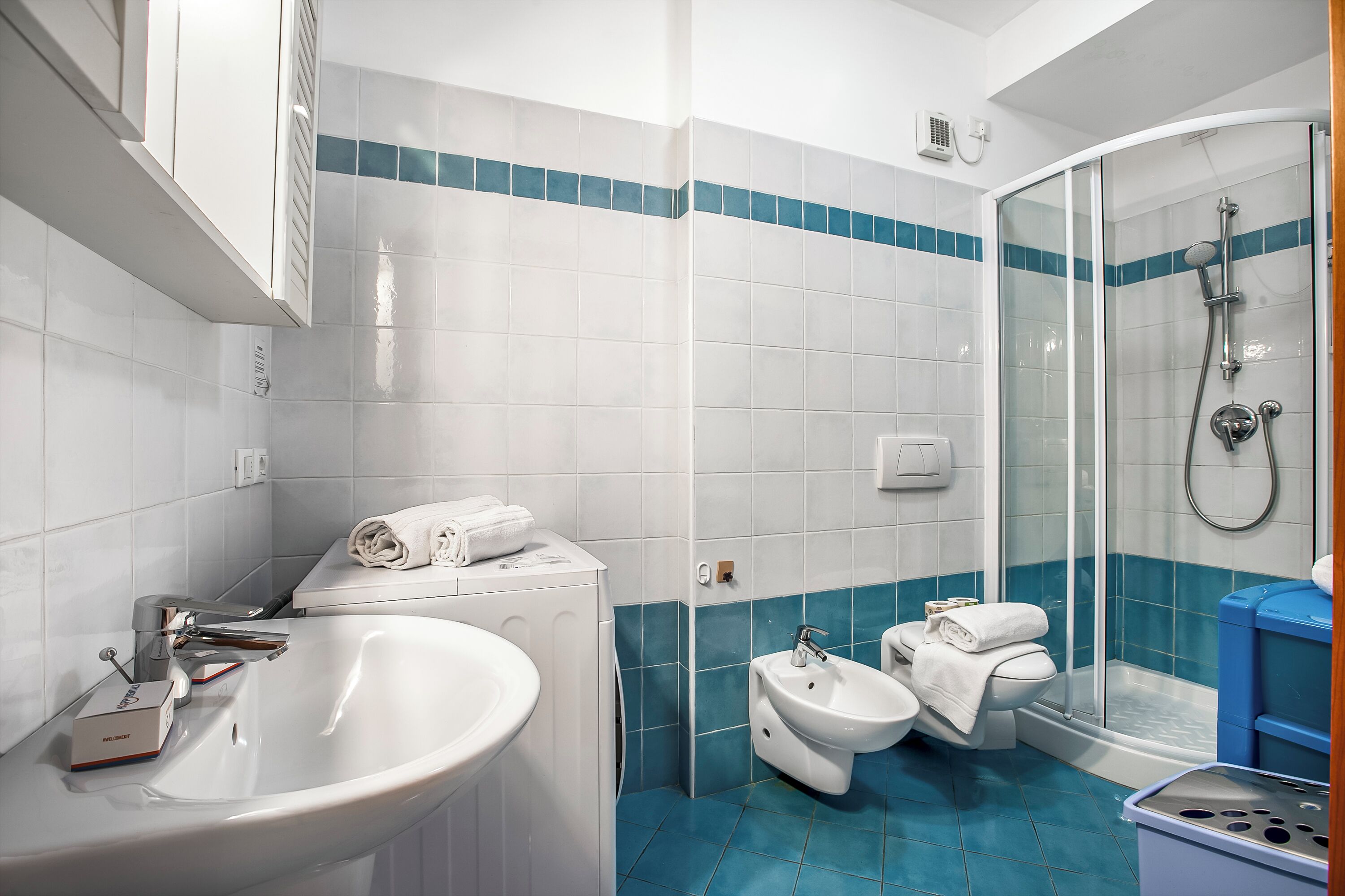Un baño moderno con lavamanos, bidé, inodoro y ducha.