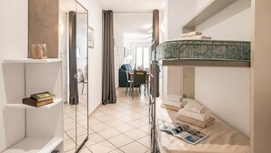 Habitación de hotel pequeña con una litera, un escritorio y una silla.