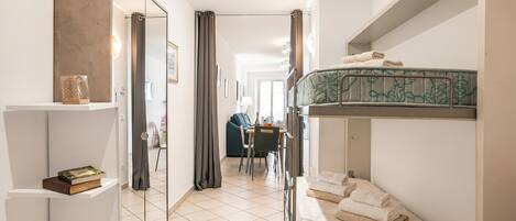 Ett litet hotellrum med en våningssäng, ett litet skrivbord och en stol.
