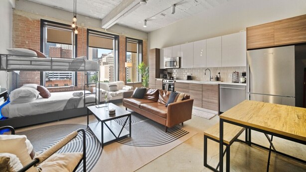 Un apartamento moderno con sala de estar, cocina y una cama litera.