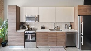 Una cocina moderna con estufa, microondas, lavaplatos y refrigerador.