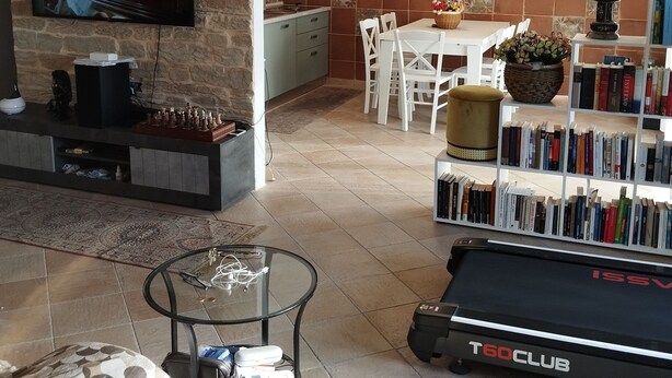 A modern living room with a TV, bookshelf, and exercise equipment. - B&B panoramico, situato a 250 metri dalla spiaggia (Praia a Mare)