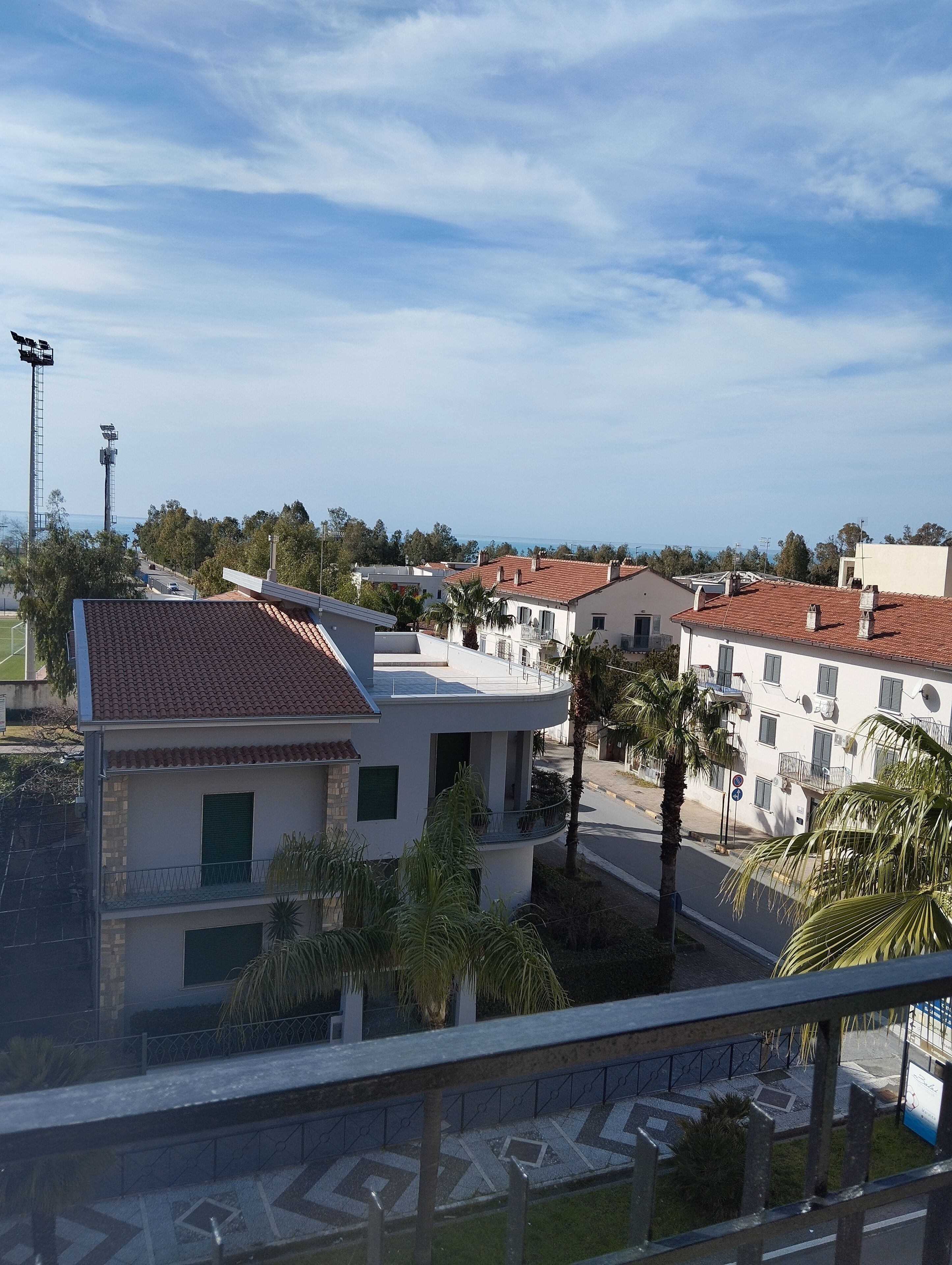 Un quartier résidentiel avec des immeubles modernes, un ciel dégagé et une vue sur la mer.