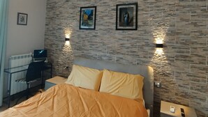 A bedroom with a bed, a desk, and two wall-mounted lights. - B&B panoramico, situato a 250 metri dalla spiaggia (Praia a Mare)