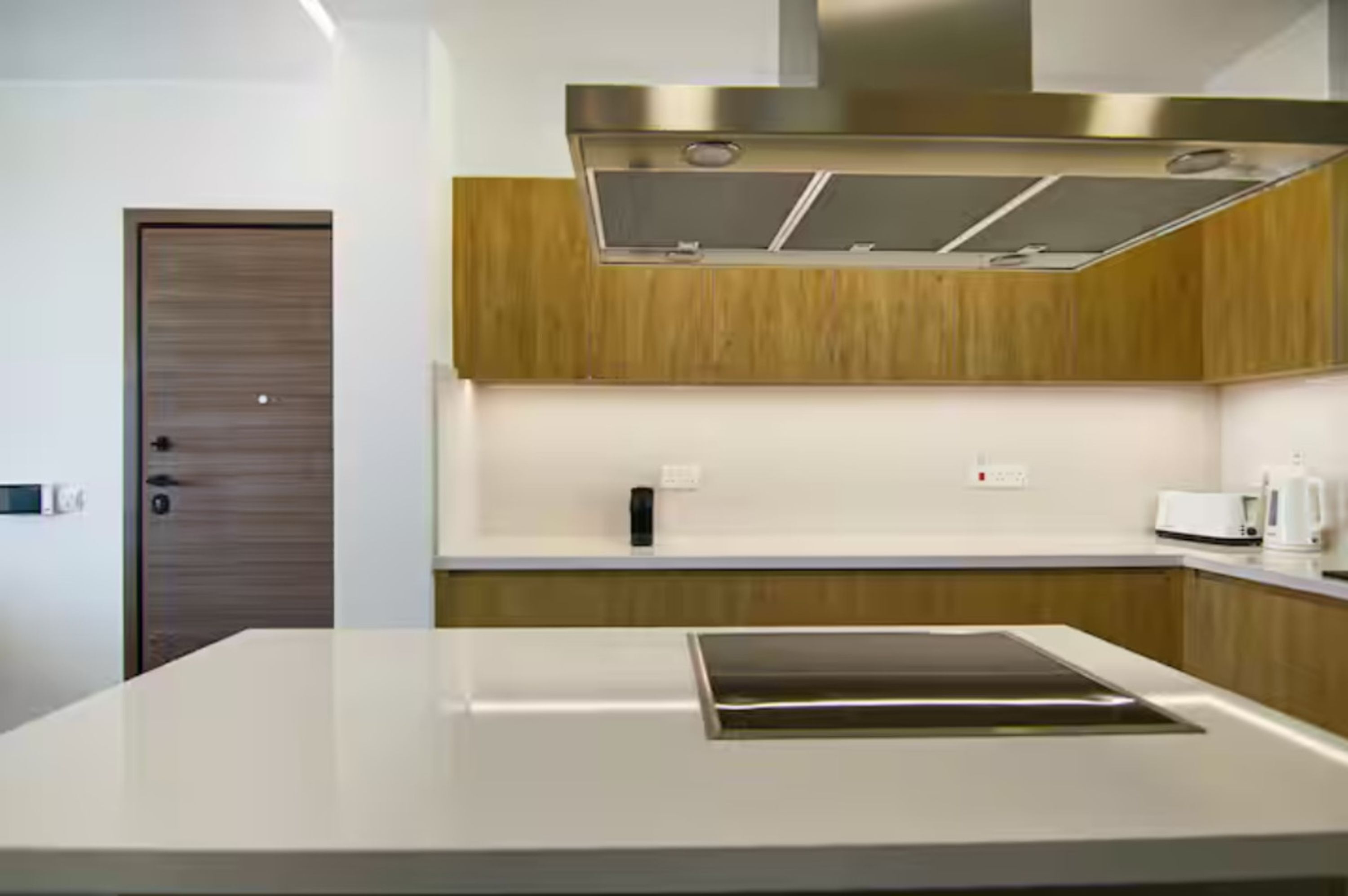Una cocina moderna con una isla central, electrodomésticos de acero inoxidable y muebles de madera.