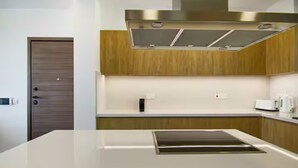 Eine moderne Küche mit Kochinsel, Edelstahlgeräten und Holzschränken.