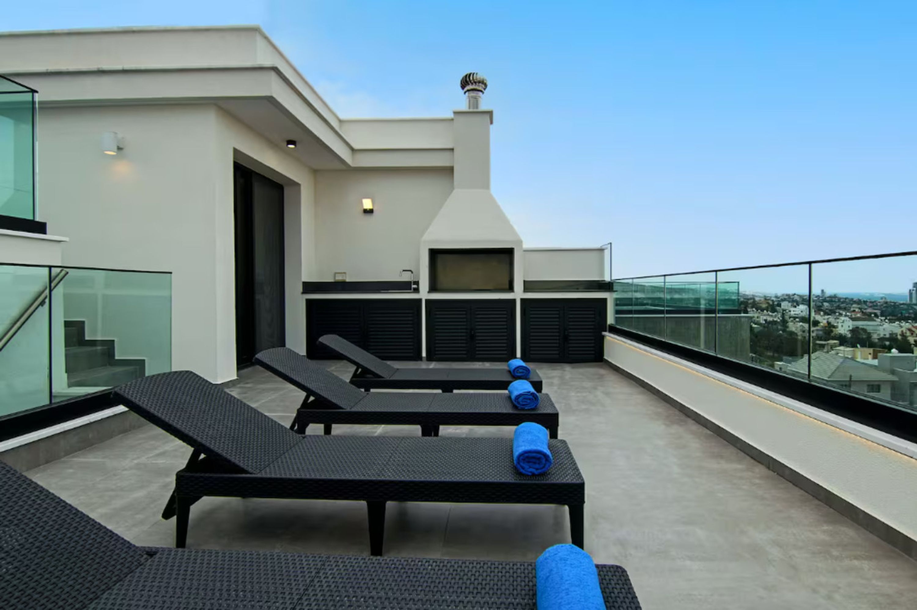 Terraza en la azotea con sillones de descanso y una chimenea.