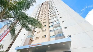 Un immeuble de grande hauteur, avec une enseigne indiquant « Résidence de prestige » à l’entrée.