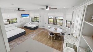 Une chambre à coucher avec un lit, un bureau et une chaise. Il y a une fenêtre donnant sur l’extérieur.