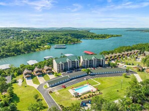 A hotel with a swimming pool, parking lot, and a view of a lake. - The Lakeview Condo Lakefront (Branson)