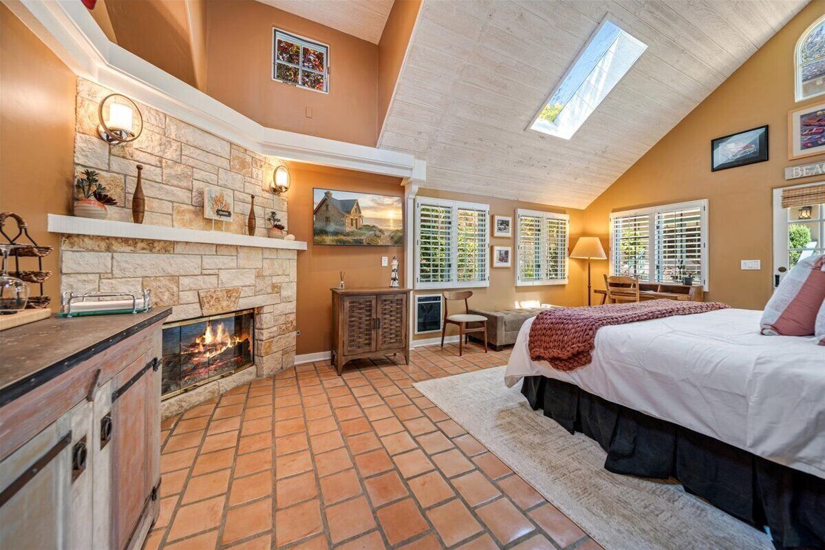 Un dormitorio con chimenea, una cama, un escritorio y una ventana con persianas.