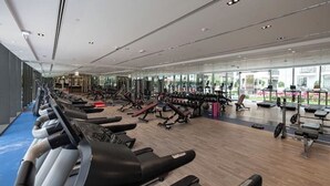 A modern gym with treadmills, weight machines, and cardio equipment. - Modern Balcony Studio in Arjan - Near Miracle Garden & Mall of the Emirates (Dubai)