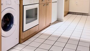 Una cocina moderna con lavadora, horno, microondas y placa de cocina integrada.