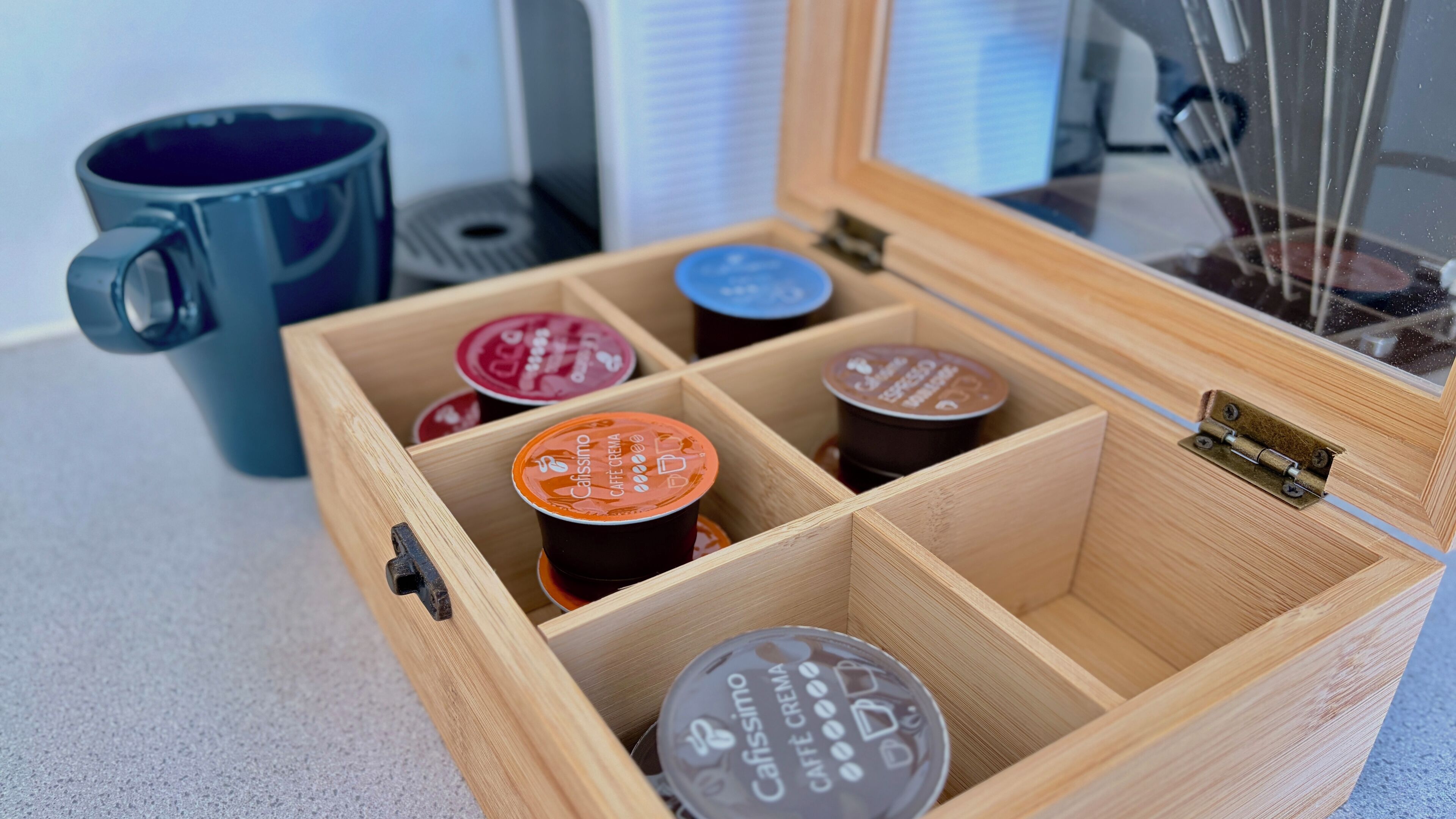 Una caja de madera con compartimentos que contienen varios envases de leche para café.