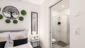 Une salle de bain moderne avec une douche à parois de verre, un lavabo blanc et un miroir.