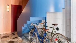 Een trap met blauwe treden, een houten wand en een betegelde muur.