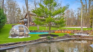 A house with a swimming pool, a pond, and outdoor seating. - Luxury meets Wilderness in the Heart of Poconos (Albrightsville)