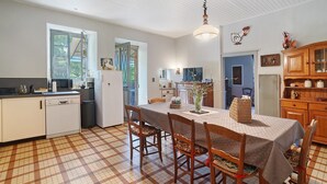 A kitchen with a dining table, chairs, a hanging light fixture, and a window. - Renovated Country House in a Charming Hamlet (Ligneyrac)