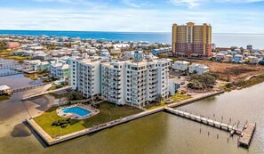A coastal residential area with a large apartment building, a swimming pool, and a marina. - Sanibel 1007 is across the street from beach with views of  Little Lagoon (Gulf Shores)
