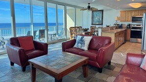 Un amplio salón con vista al océano, un comedor y una cocina.