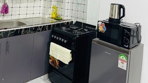 Una cucina con piano cottura a gas, forno a microonde e lavello.