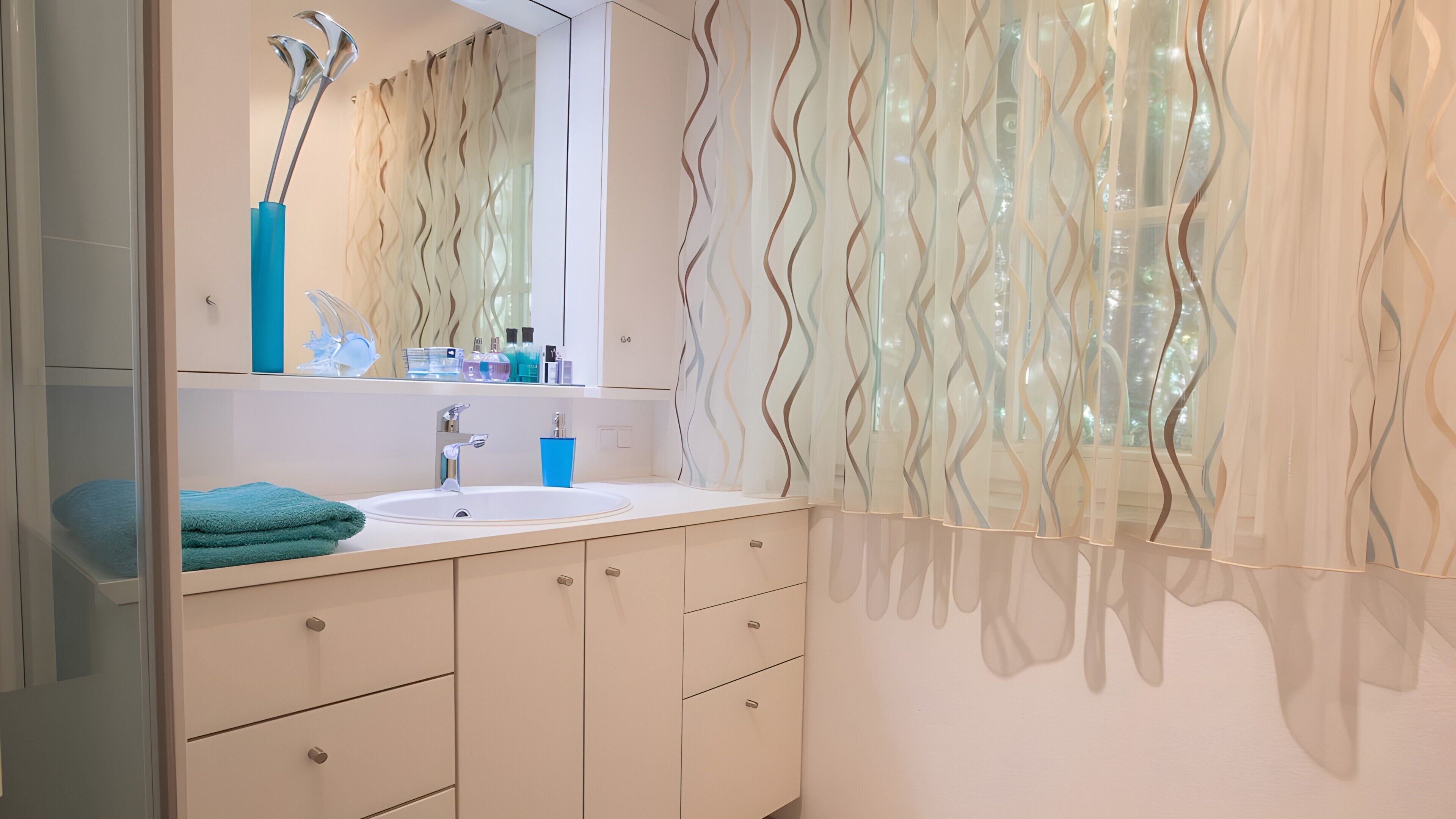 Une salle de bain avec un lavabo, un miroir et une serviette.
