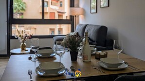 A dining table set with plates, glasses, and cutlery, a bottle of wine, and a small plant. - Chic 2 bedroom Apartment with Comunal Pool VM75 (Villamartín)