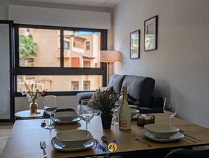 A dining table set with plates, glasses, and cutlery, a bottle of wine, and a small plant. - Chic 2 bedroom Apartment with Comunal Pool VM75 (Villamartín)