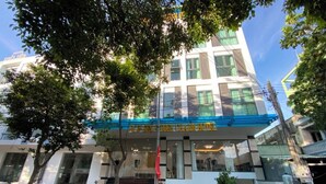 Un hôtel doté d’une façade moderne, de grandes fenêtres et d’une entrée bien visible, avec des marches menant à la porte.