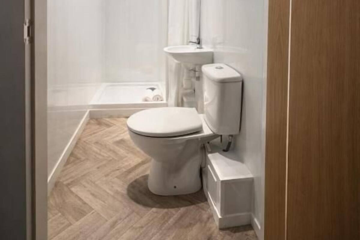 A modern bathroom with a shower, toilet, and sink.