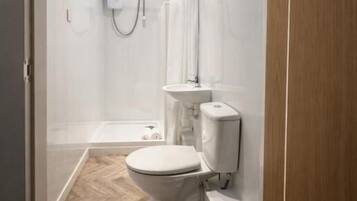 A modern bathroom with a shower, toilet, and sink.