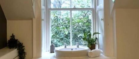 A bathroom with a window, a sink, and a towel.