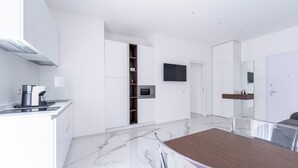 A modern kitchen with white cabinetry, a built-in microwave, and a coffee machine. - Alberti Apartments Historical Center Trapani (Trapani)