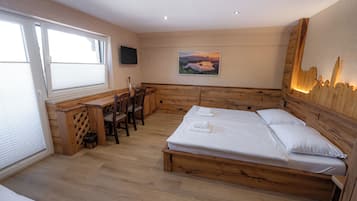 A bedroom with a wooden bed, a desk, and a chair.