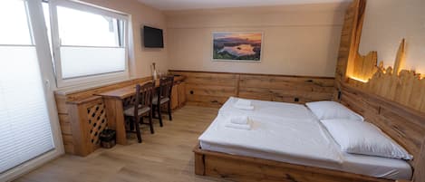 A bedroom with a wooden bed, a desk, and a chair.