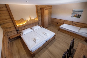 A wooden room with a bed, a bench, and a wall-mounted picture. - Bed & Breakfast LakeBled House (Bled)