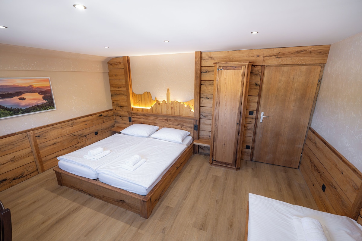 A wooden-framed bedroom with a bed, a bench, and a wardrobe.