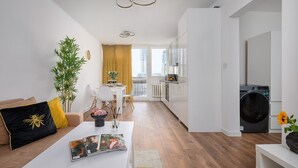 Een modern appartement met woonkamer, eethoek, keuken en wasruimte.