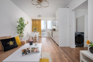Eine moderne Wohnung mit Wohnzimmer, Essbereich, Küche und Waschbereich.
