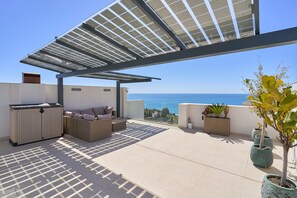 A rooftop terrace with a pergola, seating area, and potted plants. - Holiday Home 'Exclusive Getaway – Ocean View' with Sea View, Wi-Fi and Air Conditioning (Torrox)