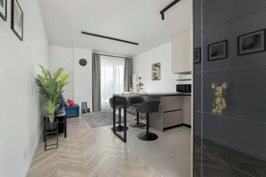 Een moderne keuken met een centraal eiland, barkrukken en een koelkast versierd met een beer.