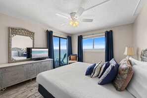 A bedroom with a bed, a TV, a ceiling fan, a dresser, and a view of the ocean. - Regency Towers 1212 | 12th Floor Gulf-Front Condo Sleeps 8 (Panama City Beach)