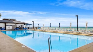 Ein Pool mit Blick auf den Ozean, ein Rettungsturm und Liegestühle am Pool.