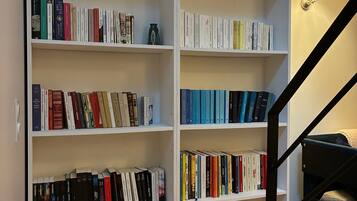 Une bibliothèque dotée de nombreuses étagères blanches, toutes remplies de livres.
