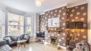 A living room with a fireplace, a television, and a lamp. - Host & Stay | Elmville (Scarborough)